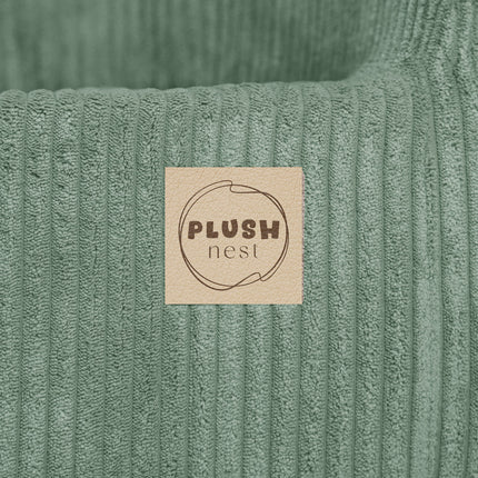 Plush Nest merklabel op groene ribstof – detail van merkafwerking